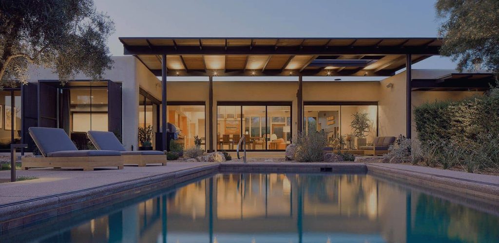 Modern home with a backyard pool at dusk