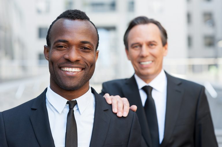 Dos profesionales sonrientes con traje de negocios