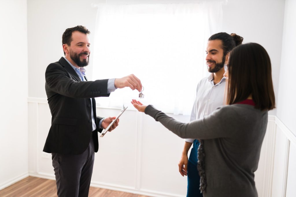 Real estate agent handing house keys to a couple