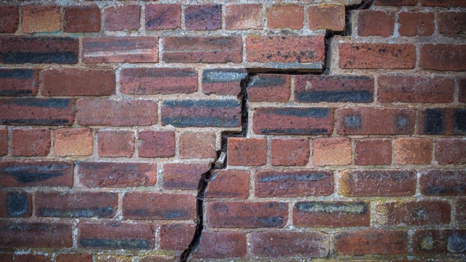 Stair-step crack running through an exterior brick wall