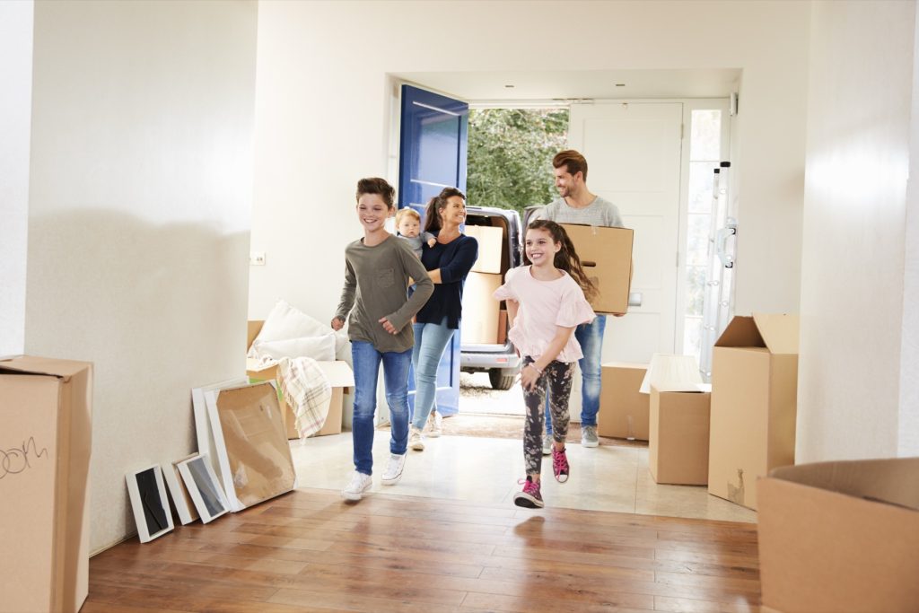 Familia llevando cajas a su nueva casa el día de la mudanza