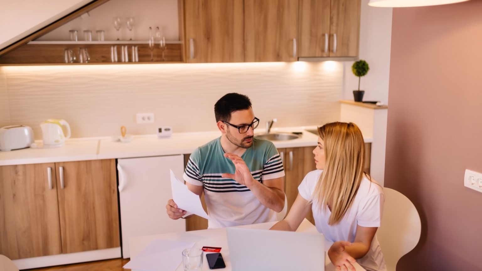 Couple reviewing household finances at a kitchen table